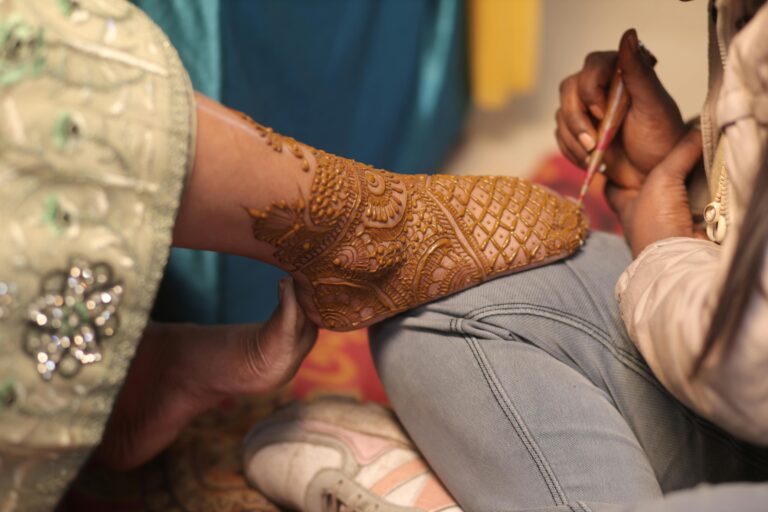 Detailed henna artistry on a foot during a traditional Indian wedding ceremony.