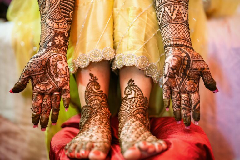 Close-up of delicate henna designs on hands and feet. Perfect for wedding and cultural themes.