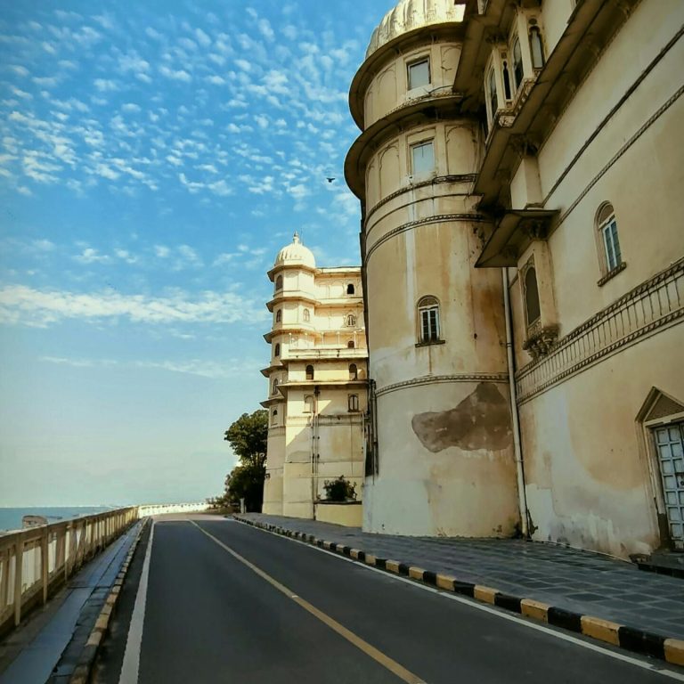 Elegant historic building against blue sky on coastal road.
